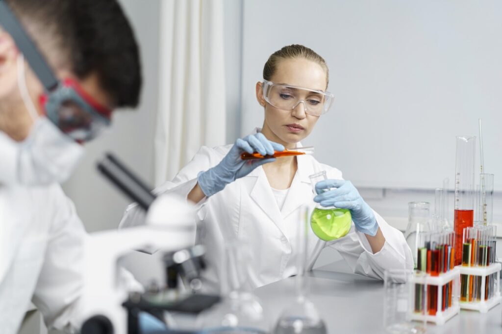 female researcher laboratory with test tubes male colleague