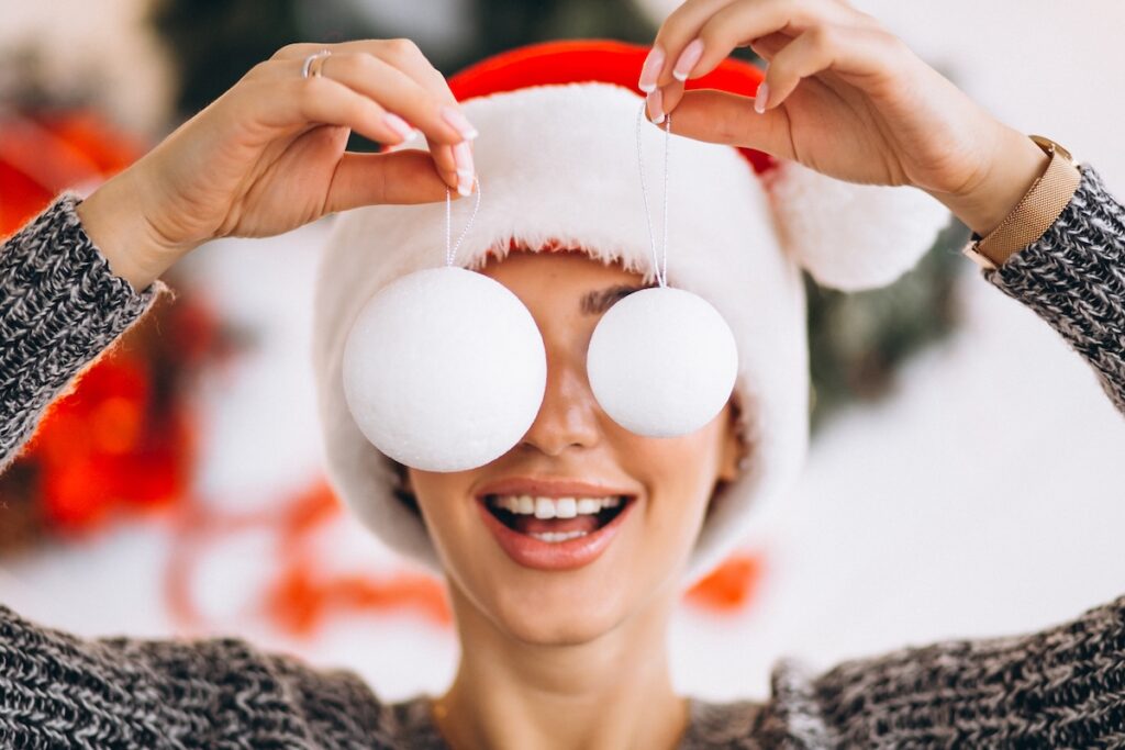 woman christmas holding christmas tree toys front her eyes