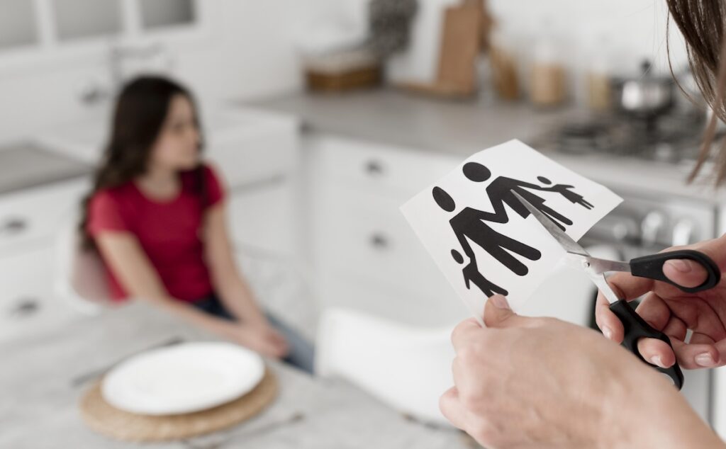 close up parent cutting paper family with scissors