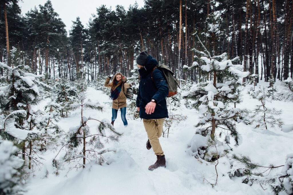 couple love have fun playing snowball snowy pine forest