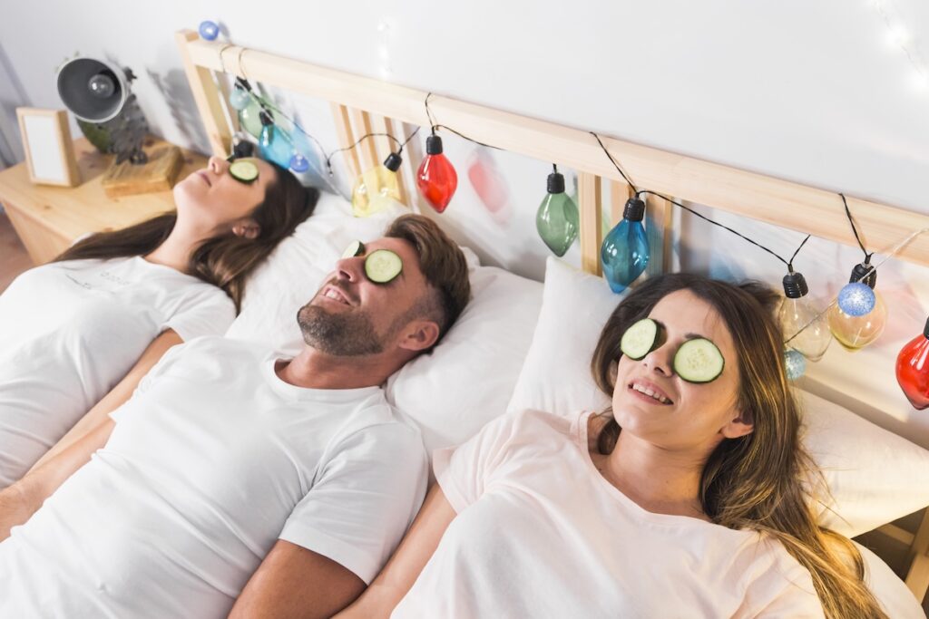 friends with cucumber slice eyes laying decorated bed