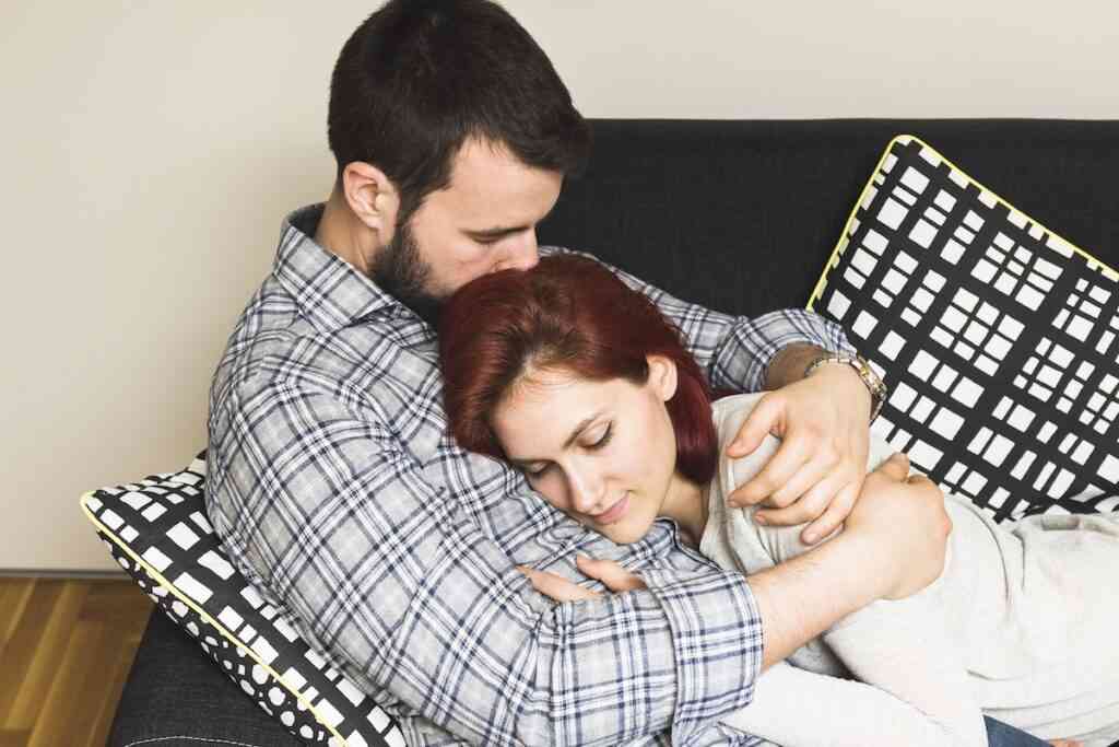 man embracing his wife sofa