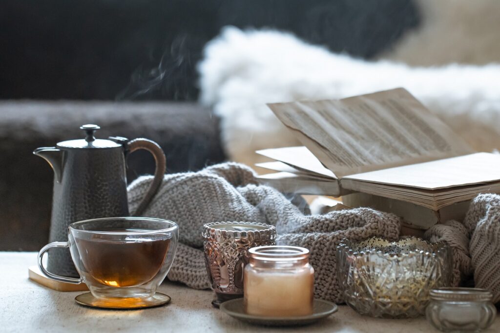 naturmort s caskoi caa cainikom knigoi i krasivymi starinnymi podsvecnikami so svecami koncepcia domasnego dekora